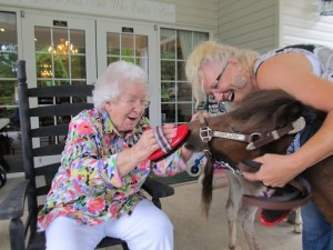 Kathy Ivy and Cole with a smiling resident of Cameron Hall Assisted Living